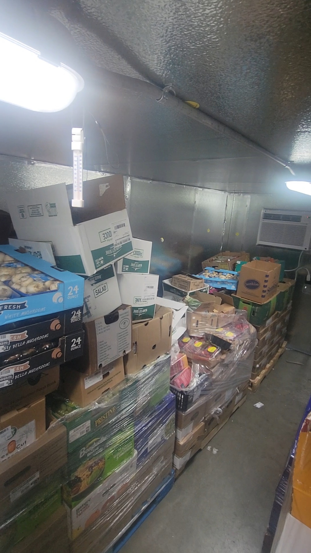 Fridge box unit filled with boxes of produce on pallets.